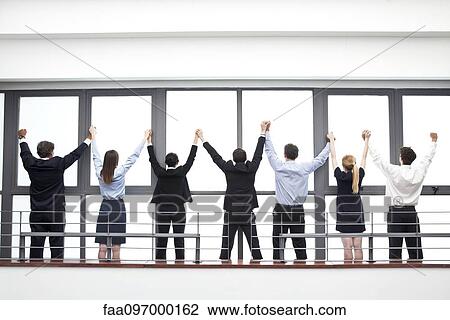 Team of business professionals exhibiting spirit of camaraderie, rear view View Large Photo Image Stock Image - Team of business professionals exhibiting spirit of camaraderie, rear view. Fotosearch
