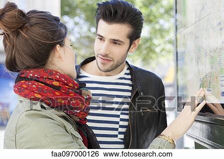 Tourist couple looking at city map discussing sightseeing plan View Large Photo Image Stock Photograph - Tourist couple looking at city map discussing sightseeing plan. Fotosearch