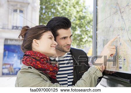 Tourist couple looking at outdoor city map at tourist information station View Large Photo Image Stock Photography - Tourist couple looking at outdoor city map at tourist information station. Fotosearch