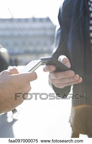Wirelessly sharing data between smartphones View Large Photo Image Stock Photography - Wirelessly sharing data between smartphones. Fotosearch