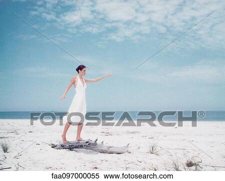 Woman balancing on driftwood on beach, arms out View Large Photo Image Stock Photography - Woman balancing on driftwood on beach, arms out. Fotosearch