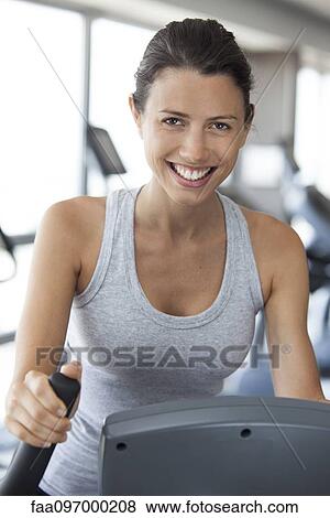 Stock Photo - Woman exercising in health club, portrait. Fotosearch