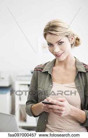 Stock Photo - Woman holding cell phone. Fotosearch