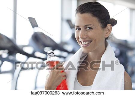Stock Image - Woman hydrating after working out. Fotosearch