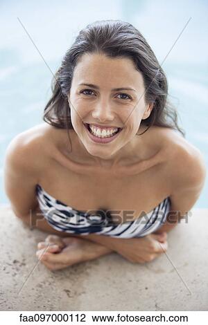 Stock Image - Woman relaxing in pool, portrait. Fotosearch