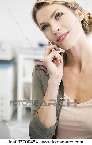 Woman talking on cell phone, head tilted View Large Photo Image Picture - Woman talking on cell phone, head tilted. Fotosearch