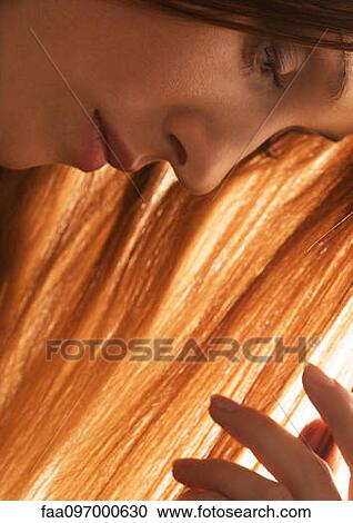 Stock Image - Woman touching hair, close-up. Fotosearch