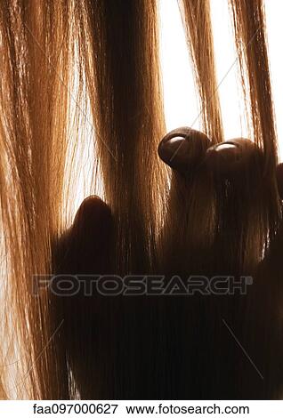 Stock Photo - Woman touching hair, close-up. Fotosearch