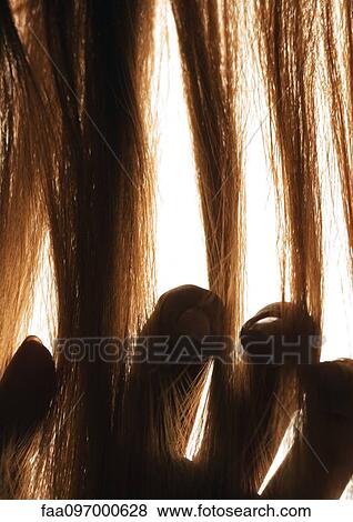Stock Photo - Woman touching hair, close-up. Fotosearch