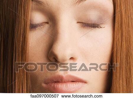 Stock Photo - Woman with eyes shut, close-up. Fotosearch