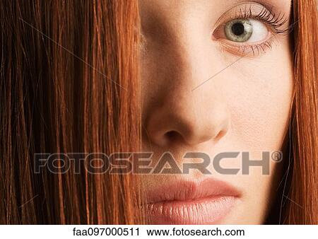 Stock Image - Woman's face and red hair, portrait. Fotosearch