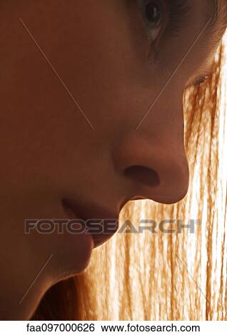 Stock Photograph - Woman's face and straight hair in background, side view. Fotosearch