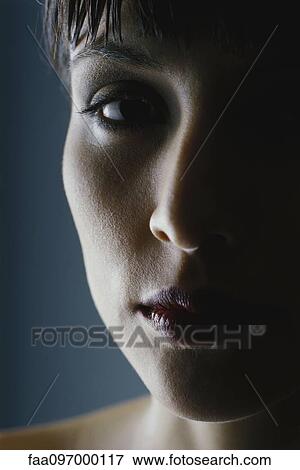 Stock Photo - Woman's face in shadow, close-up. Fotosearch
