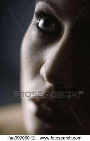 Stock Image - Woman's face, looking up, close-up. Fotosearch