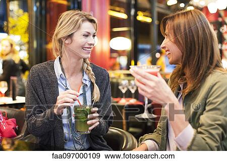 Stock Photo - Women enjoying cocktail at bar. Fotosearch