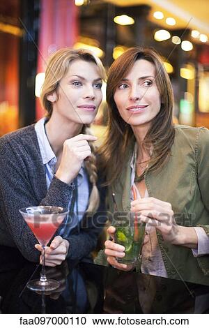 Stock Image - Women having cocktail at bar. Fotosearch