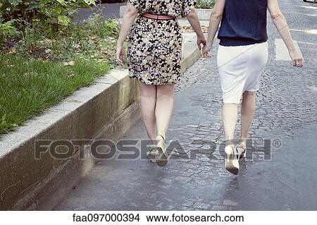 Picture - Women holding hands, rear view. Fotosearch