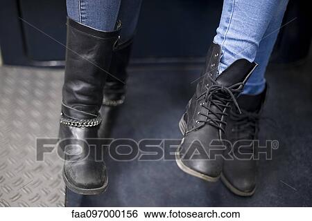 Women sitting together on subway train, close-up of boots View Large Photo Image Stock Photograph - Women sitting together on subway train, close-up of boots. Fotosearch