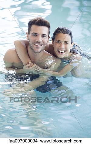 Picture - Young couple in pool together, portrait. Fotosearch