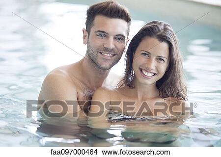 Picture - Young couple in pool together, portrait. Fotosearch