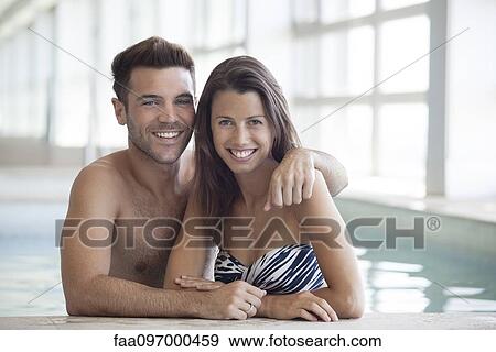 Stock Photo - Young couple in pool together, portrait. Fotosearch