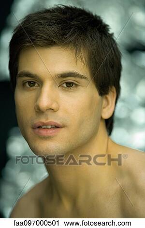 Stock Image - Young man looking at camera, portrait. Fotosearch