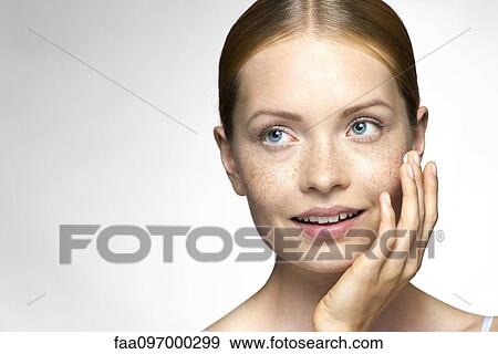 Young woman applying moisturizer to face View Large Photo Image Stock Photo - Young woman applying moisturizer to face. Fotosearch