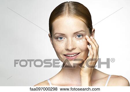 Stock Photo - Young woman applying undereye cream. Fotosearch
