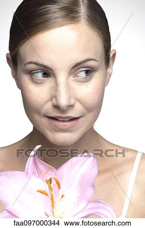 Picture - Young woman holding orchid. Fotosearch