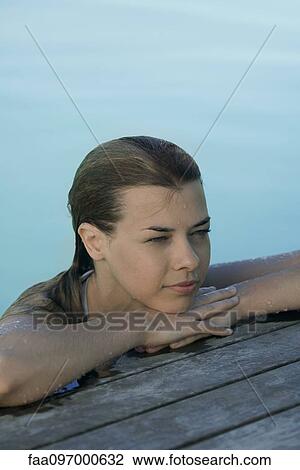 Young woman leaning on poolside View Large Photo Image Stock Image - Young woman leaning on poolside. Fotosearch
