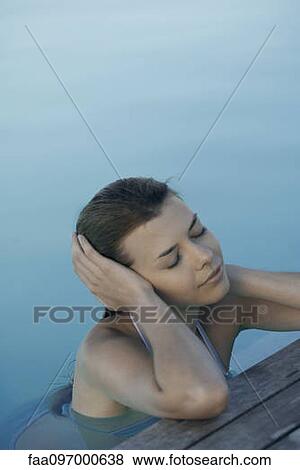 Young woman leaning on poolside, covering ears View Large Photo Image Stock Photo - Young woman leaning on poolside, covering ears. Fotosearch