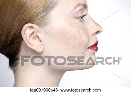 Stock Photograph - Young woman wearing red lipstick, profile. Fotosearch
