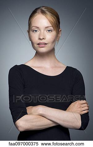 Stock Photography - Young woman with arms folded, portrait. Fotosearch