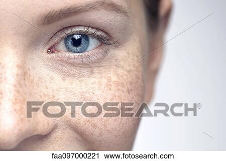 Stock Image - Young woman with freckles smiling, close-up. Fotosearch