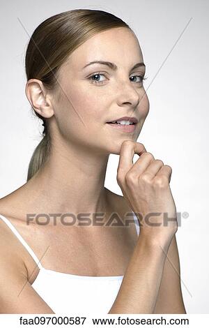 Stock Photo - Young woman with hand under chin. Fotosearch