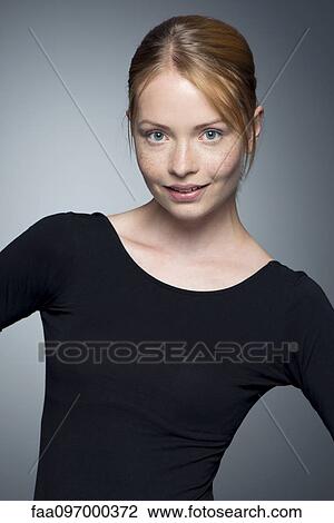 Stock Image - Young woman with hands on hips, portrait. Fotosearch