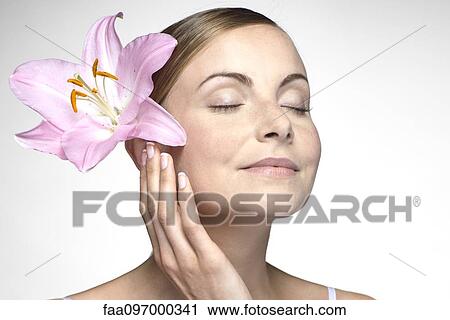 Young woman with orchid in hair View Large Photo Image Stock Image - Young woman with orchid in hair. Fotosearch