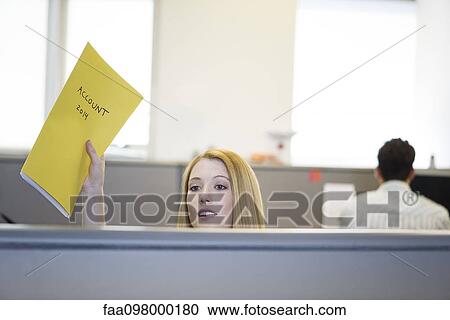 Stock Image - Accountant in office cubicle handing accounts file to out-of-frame associate. Fotosearch