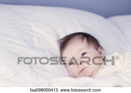 Stock Image - Baby lying in bed. Fotosearch