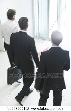 Business associates chatting while leaving office building together View Large Photo Image Stock Image - Business associates chatting while leaving office building together. Fotosearch