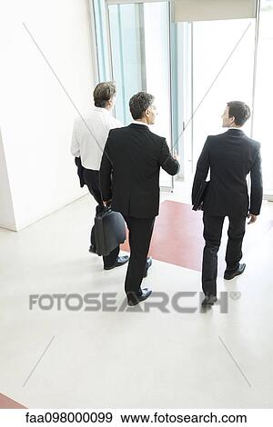 Stock Photo - Business associates leaving office building together. Fotosearch