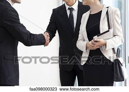 Stock Image - Business associates shaking hands. Fotosearch