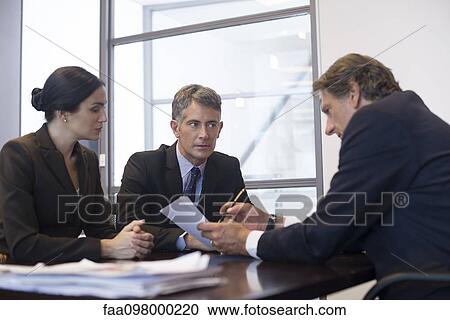 Stock Image - Business meeting, business associates reviewing document. Fotosearch