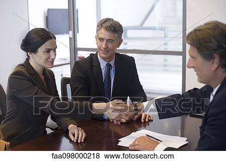 Business meeting, businesswoman shaking hands with associate View Large Photo Image Stock Photo - Business meeting, businesswoman shaking hands with associate. Fotosearch
