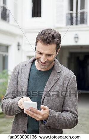 Businessman using smartphone on the move View Large Photo Image Stock Photograph - Businessman using smartphone on the move. Fotosearch