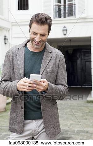 Businessman using smartphone on the move View Large Photo Image Stock Photography - Businessman using smartphone on the move. Fotosearch