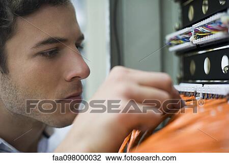 Computer technician performing maintenance work on networking equipment View Large Photo Image Stock Image - Computer technician performing maintenance work on networking equipment. Fotosearch