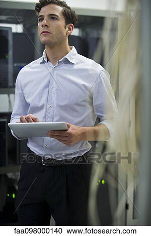 Computer technician using digital tablet performing maintenance check of mainframe equipment View Large Photo Image Stock Image - Computer technician using digital tablet performing maintenance check of mainframe equipment. Fotosearch