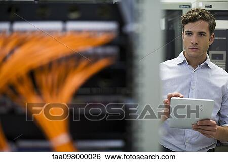 Computer technician using digital tablet performing maintenance check of mainframe equipment View Large Photo Image Stock Photograph - Computer technician using digital tablet performing maintenance check of mainframe equipment. Fotosearch