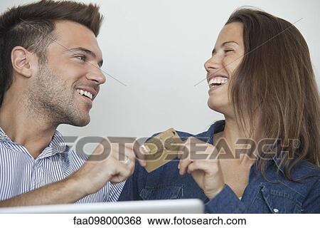 Stock Photo - Couple using credit card to shop online. Fotosearch